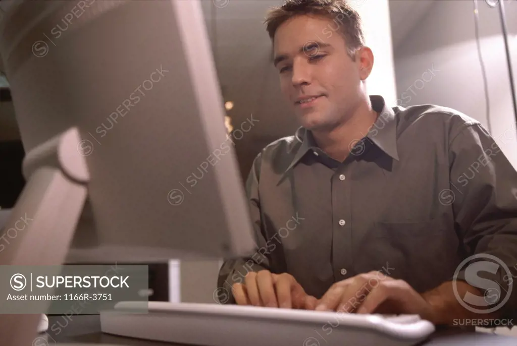 Low angle view of a businessman sitting in front of a computer monitor