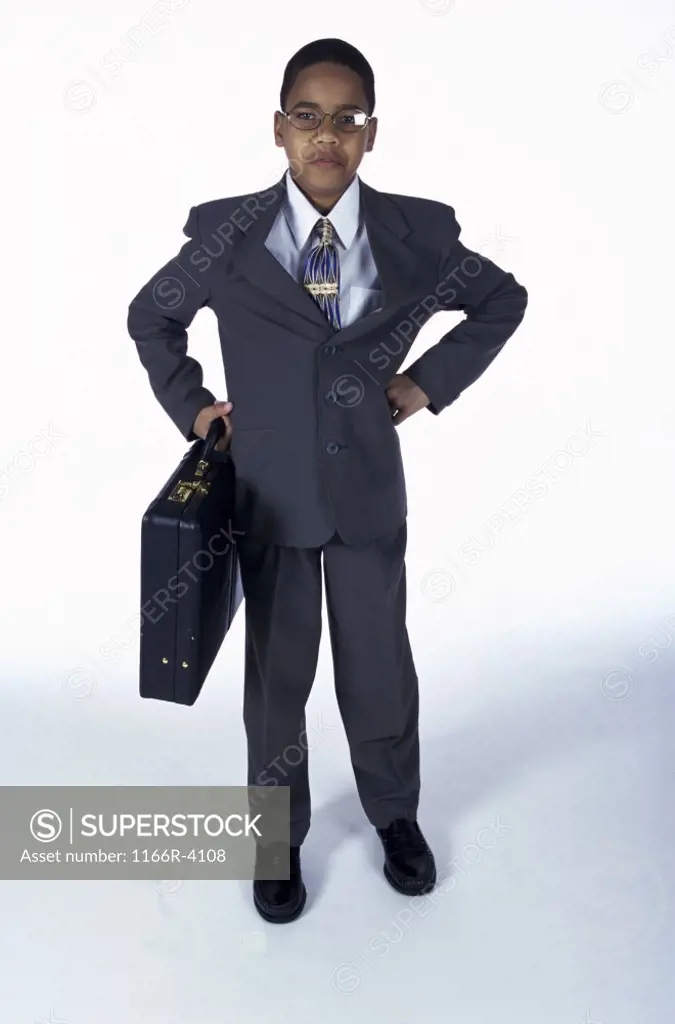 Portrait of a young boy dressed as a businessman holding a briefcase