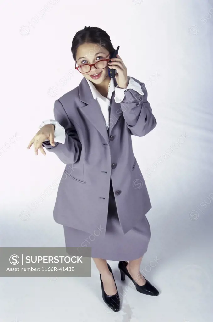 Portrait of a young girl dressed as a businesswoman talking on a mobile phone