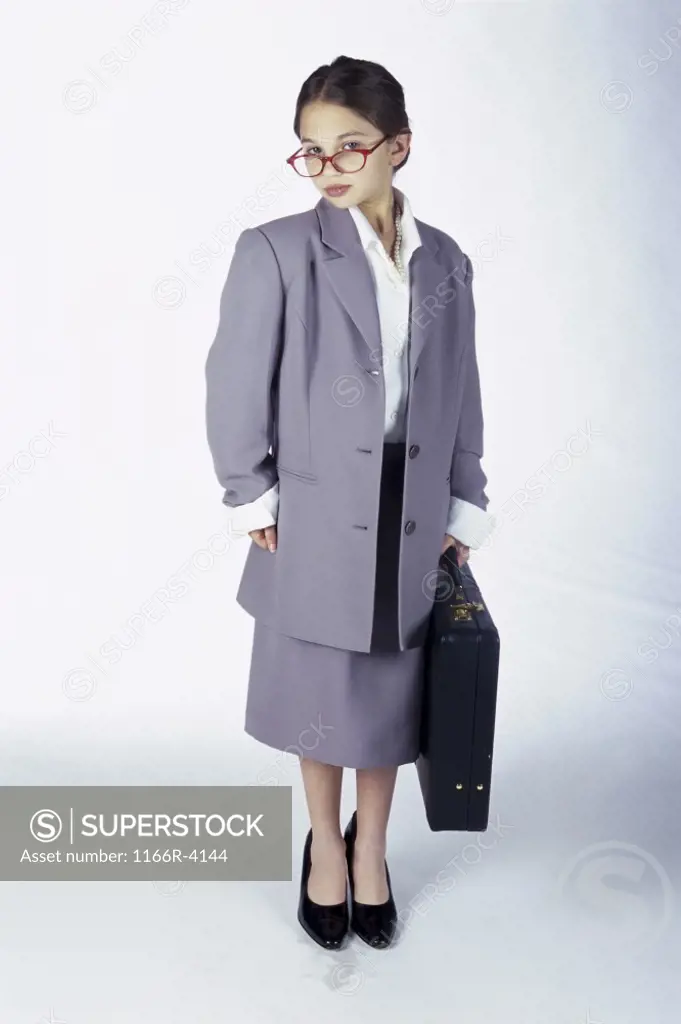 Portrait of a young girl dressed as a businesswoman holding a briefcase