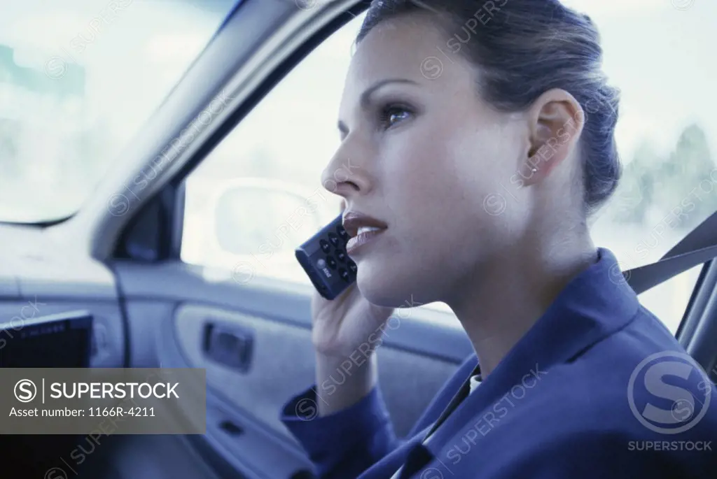 Side profile of a businesswoman talking on a mobile phone in a car