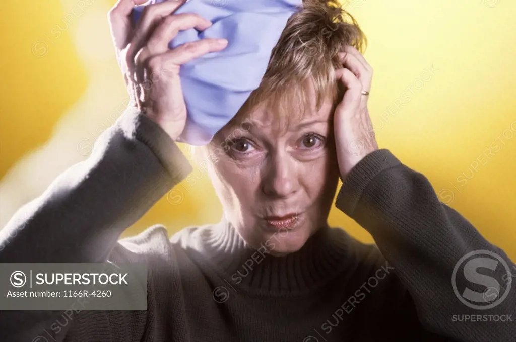 Portrait of a woman holding a cold pack on her head