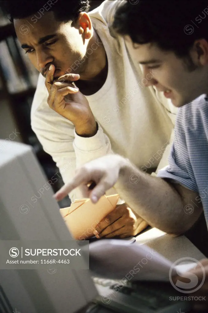 Two young men looking at a computer monitor
