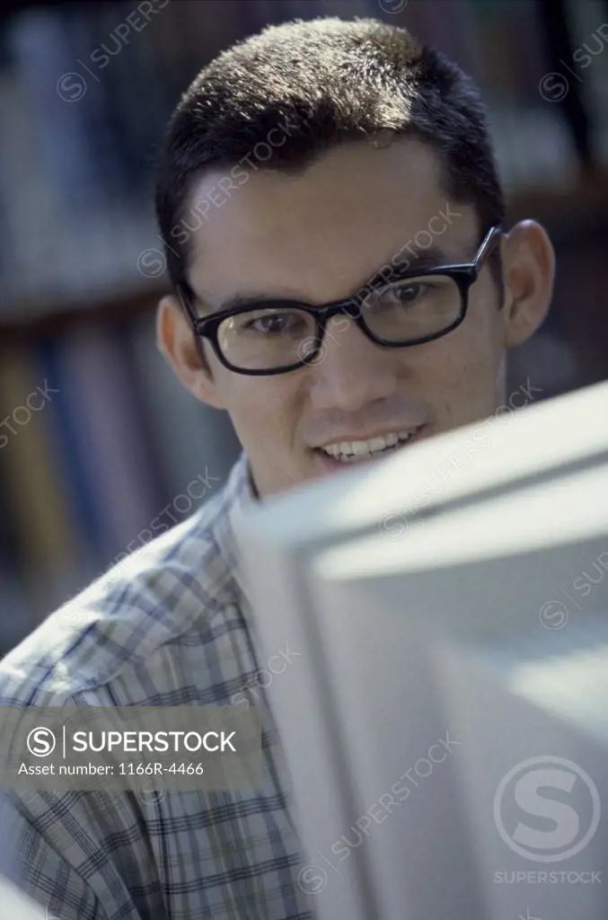 Portrait of a young man sitting in front of a computer monitor
