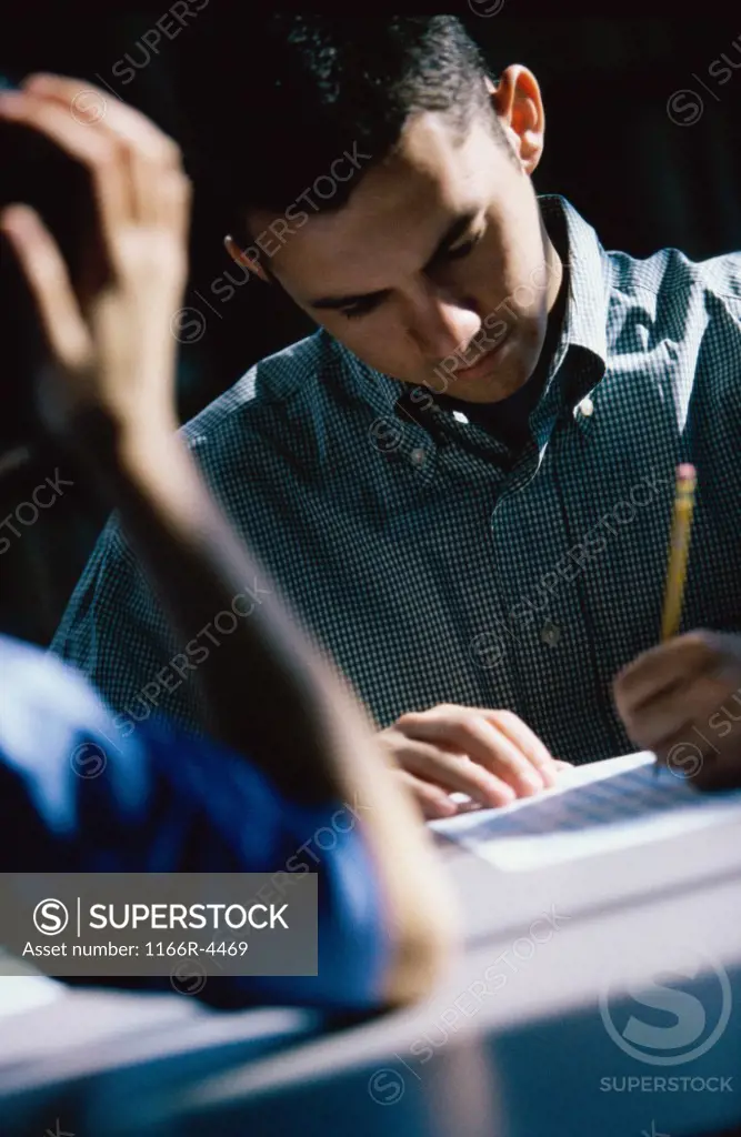 Male student writing during an examination
