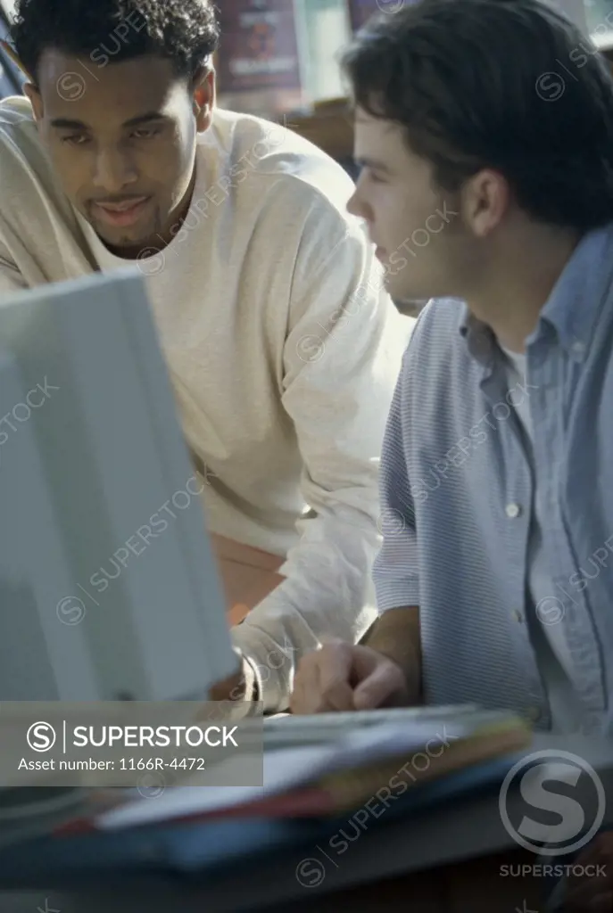 Two young men looking at a computer monitor