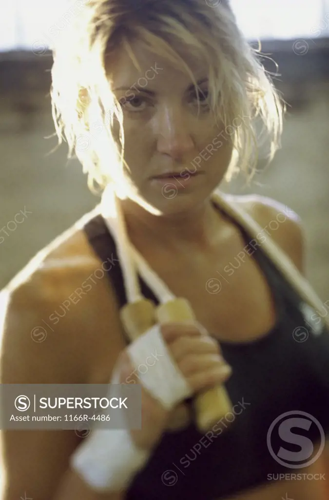 Portrait of a young woman holding a jump rope around her neck