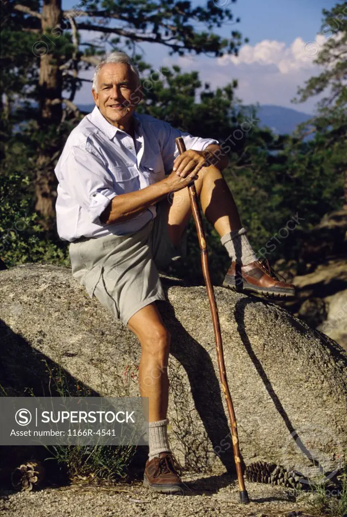 Portrait of a senior man sitting on a rock