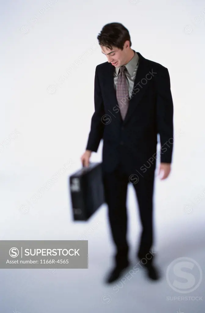 Businessman looking down while holding a briefcase
