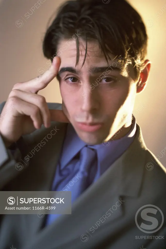 Portrait of a businessman with a finger against his head