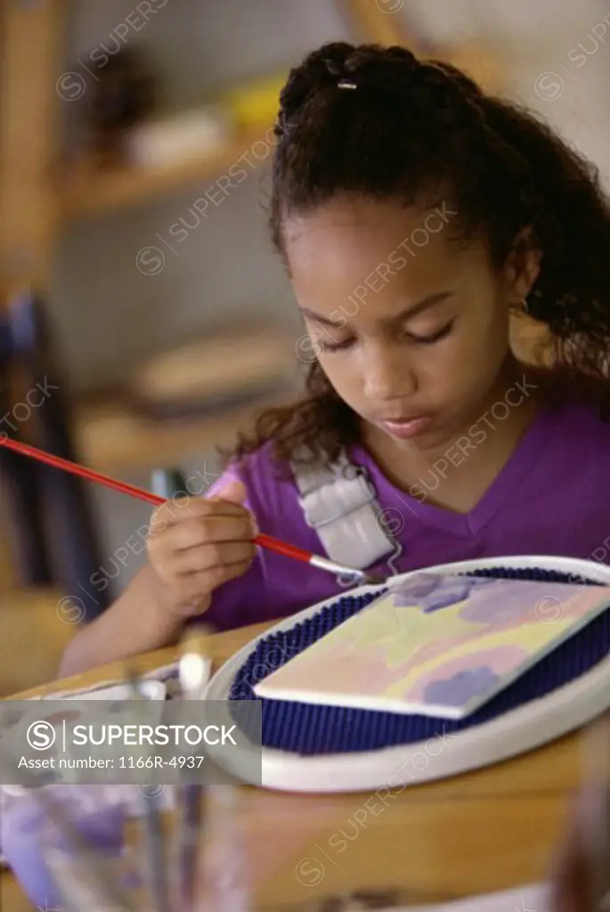 Girl painting with watercolor paints
