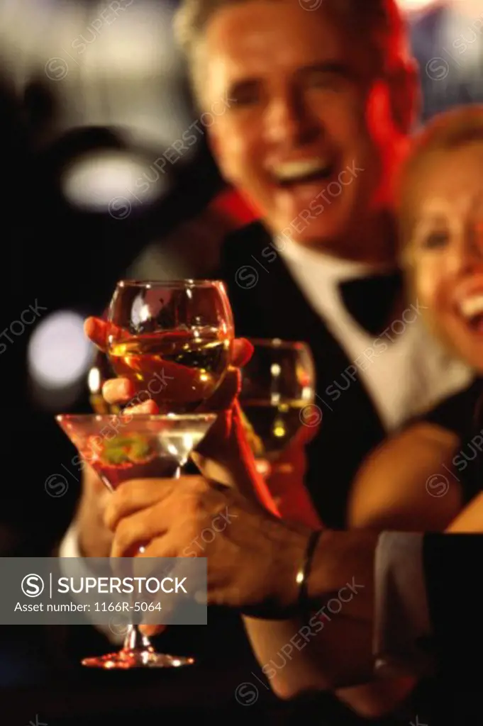 Two people toasting at a bar