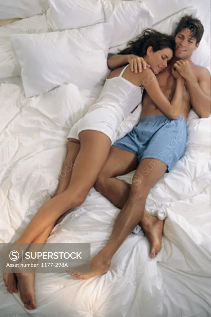High angle view of a young couple sleeping on the bed