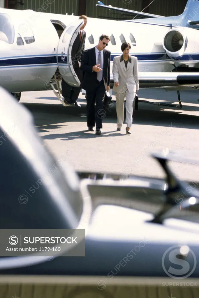 Businesswoman and a businessman walking side by side at an airport