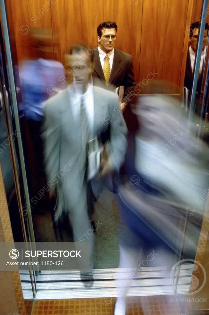 Businessman and a businesswoman exiting an elevator