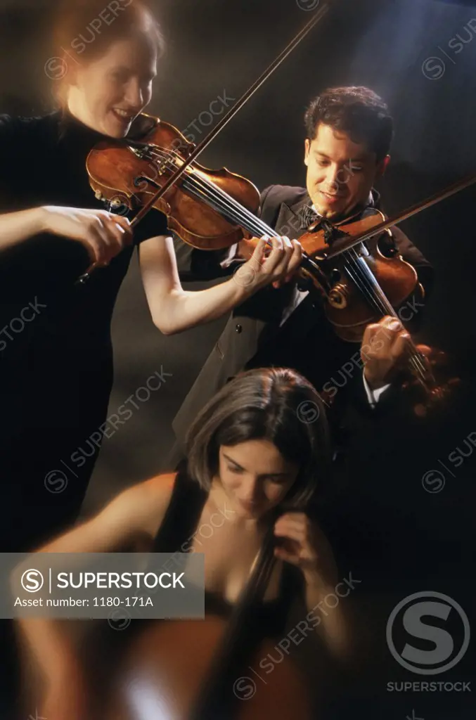 Two young women and a young man playing violins and cello