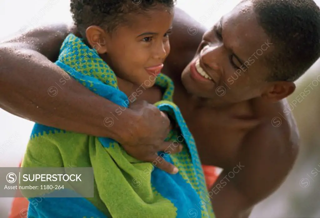 Mid adult man hugging his son on the beach
