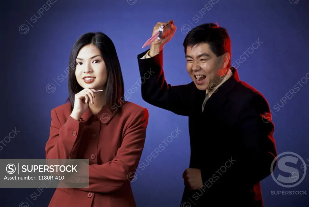 Portrait of a businesswoman with a businessman holding a dagger