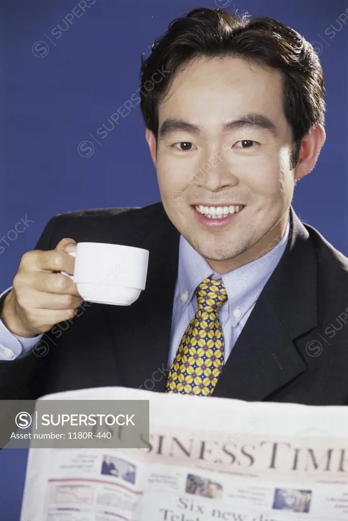 Portrait of a businessman smiling and holding a coffee cup