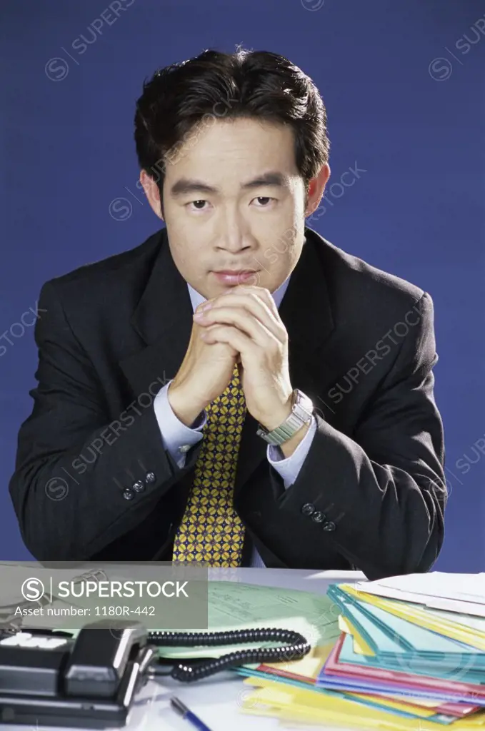 Portrait of a businessman seated behind an office desk