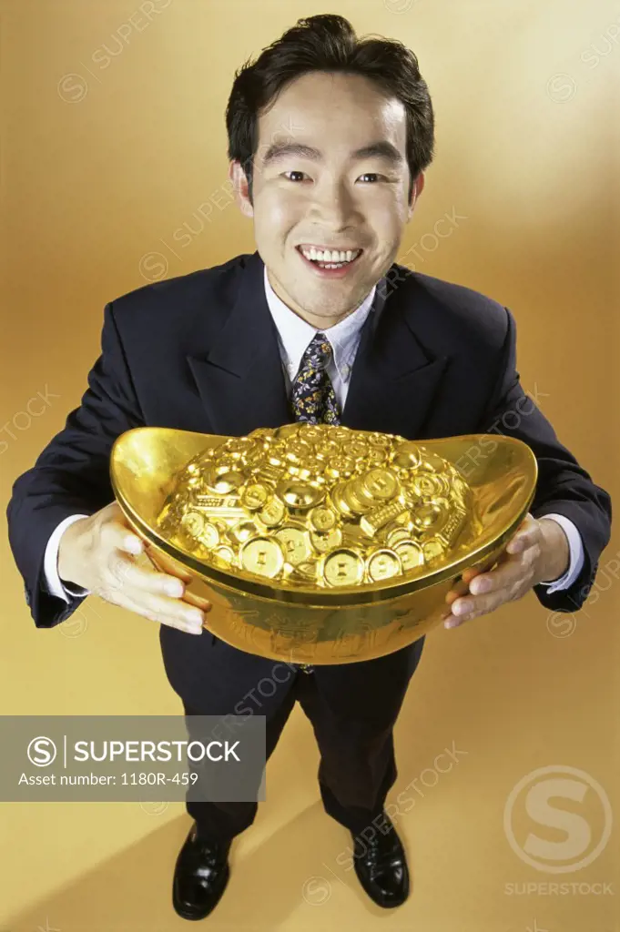 Portrait of a businessman holding a pot of gold