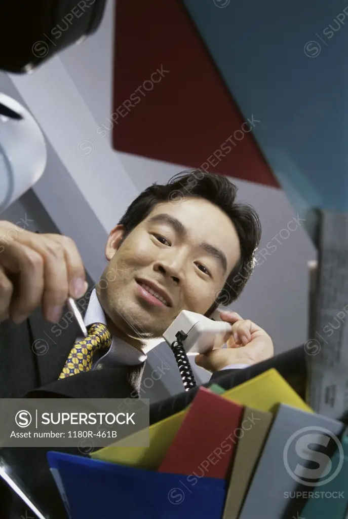 Low angle view of a businessman talking on landline telephone