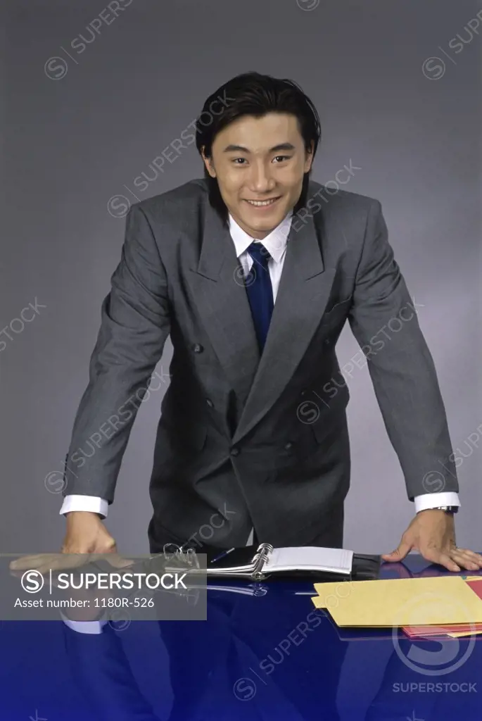 Portrait of a businessman standing behind an office desk