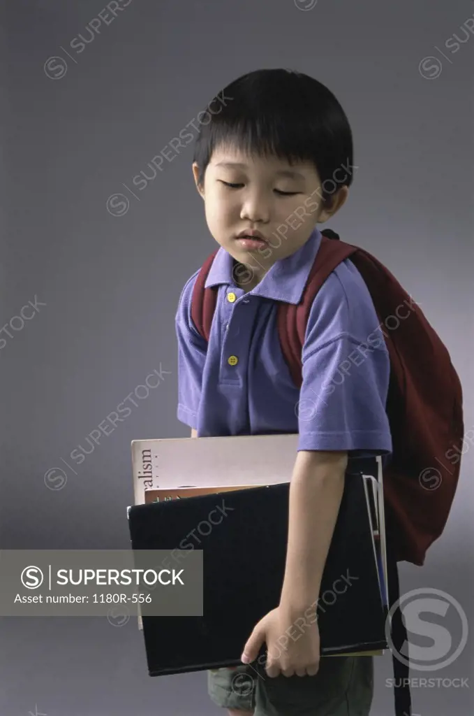 Portrait of a boy carrying book and a backpack