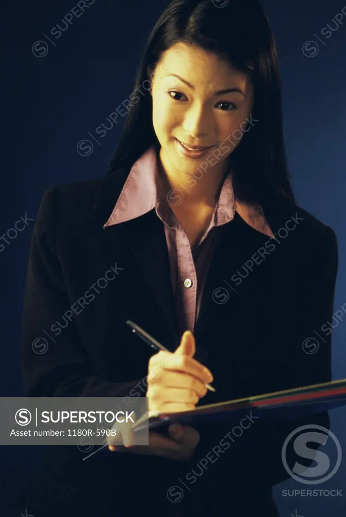 Portrait of a businesswoman writing on paper