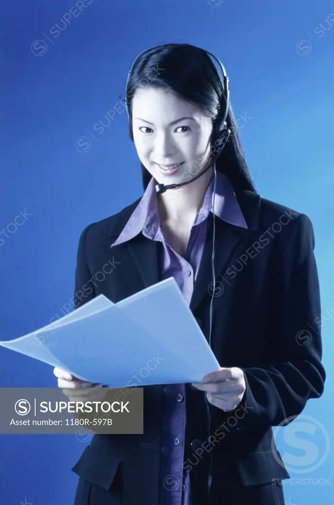 Portrait of a customer service representative holding sheets of paper