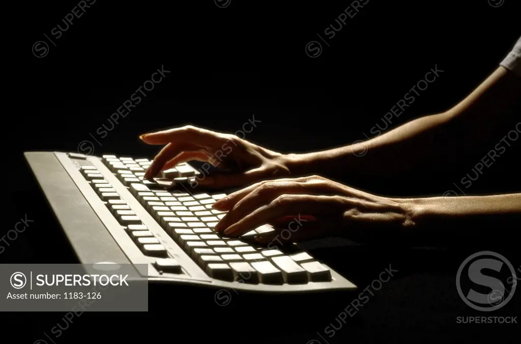 Close-up of a person's hands typing on a computer keyboard
