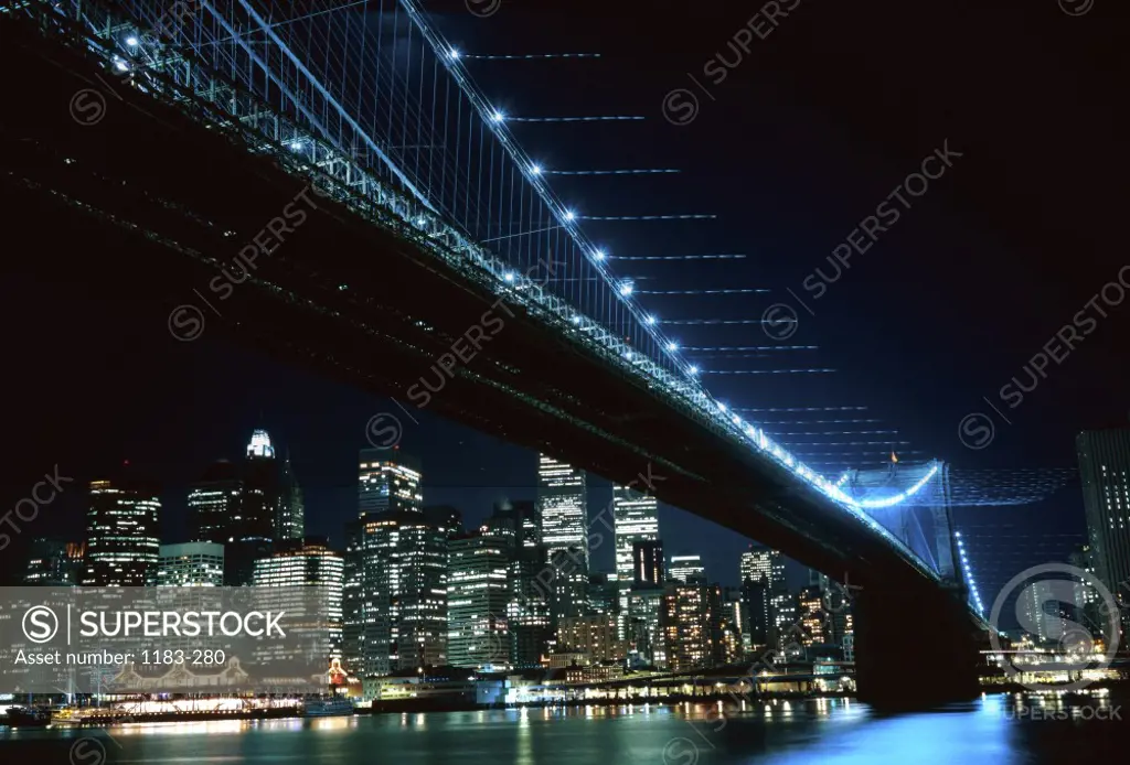 Low angle view of a suspension bridge across a river lit up at night, Brooklyn Bridge, Brooklyn, New York City, New York, USA