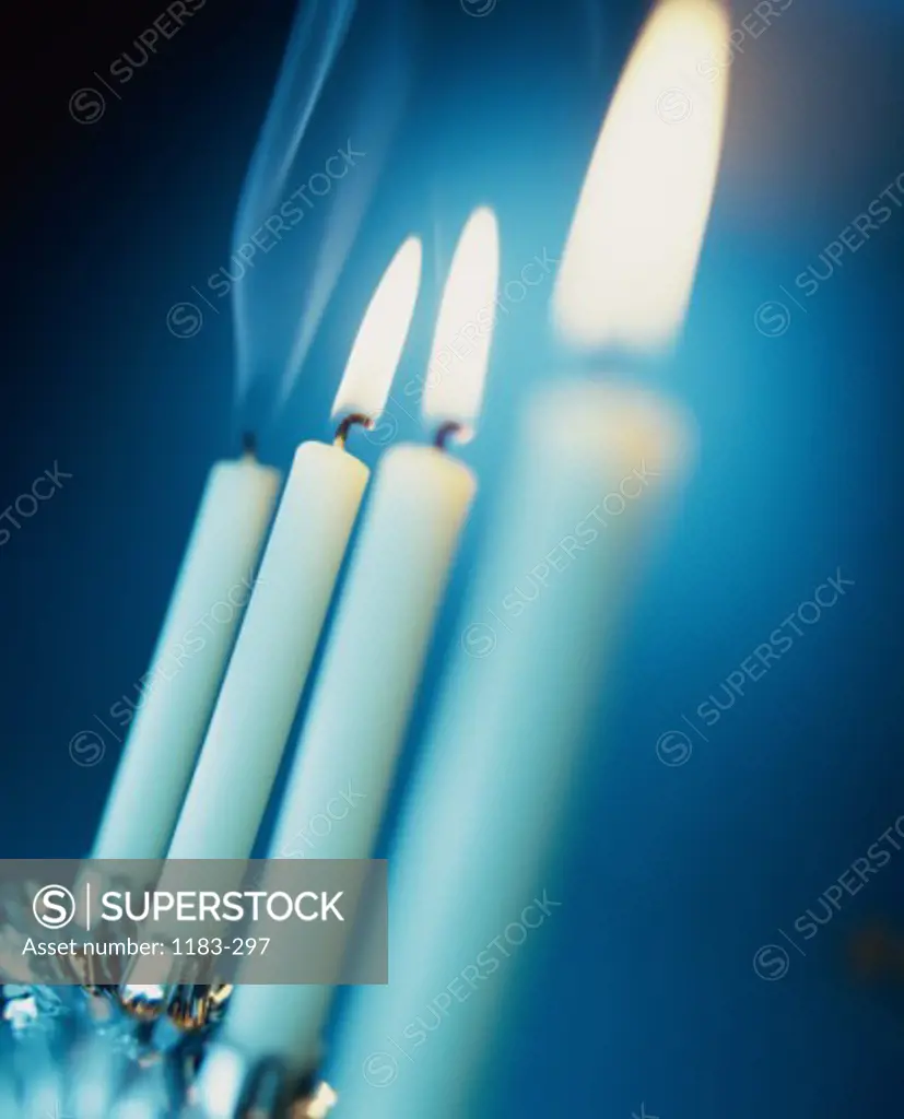 Close-up of three lit candles in a row