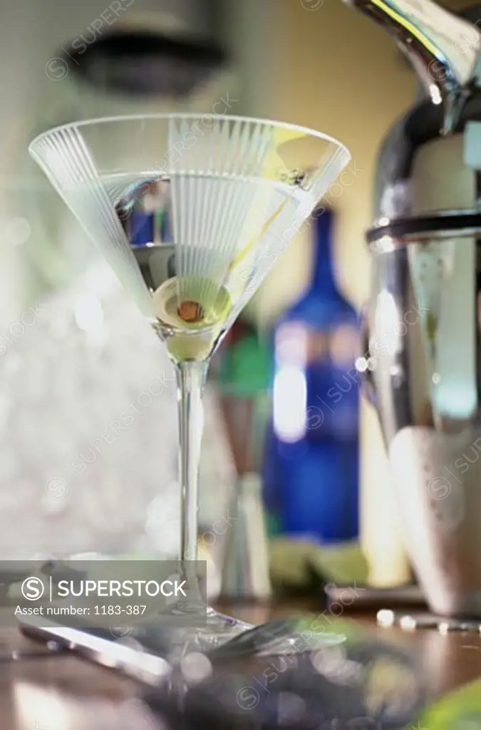 Close-up of a martini glass with a green olive in it