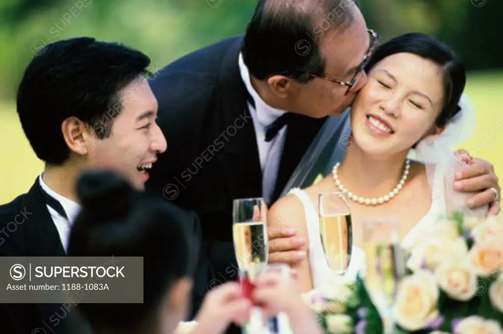 Close-up of a father kissing the bride
