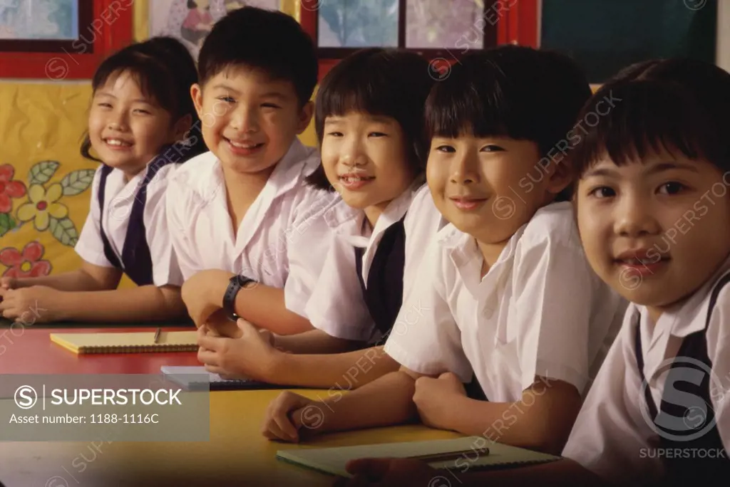 Group of children sitting in a row and smiling