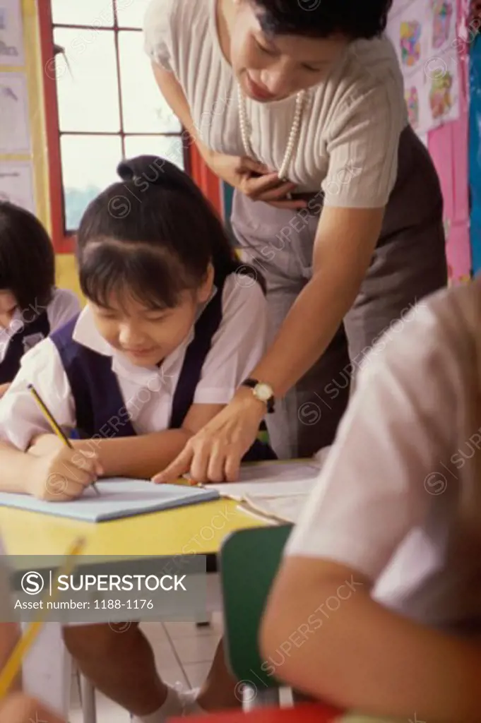 Teacher helping her students in a classroom