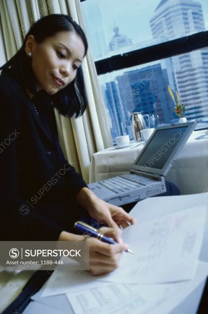 Businesswoman sitting on a bed in a hotel room