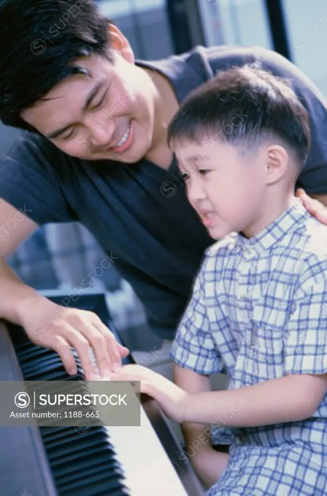 Father teaching his son the piano