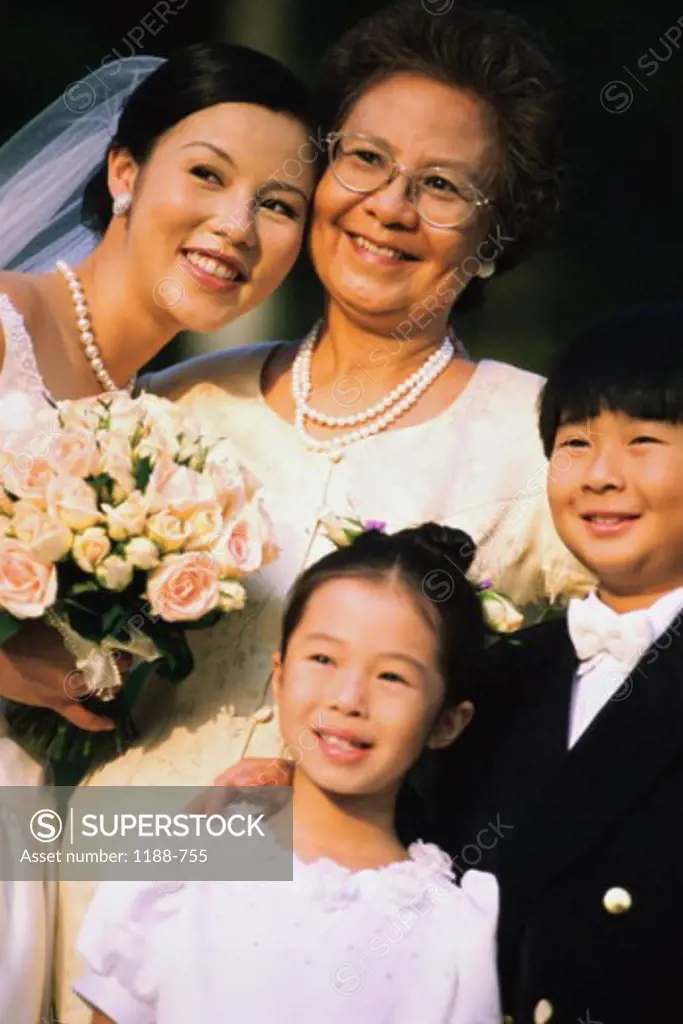 Bride smiling with her mother and two children