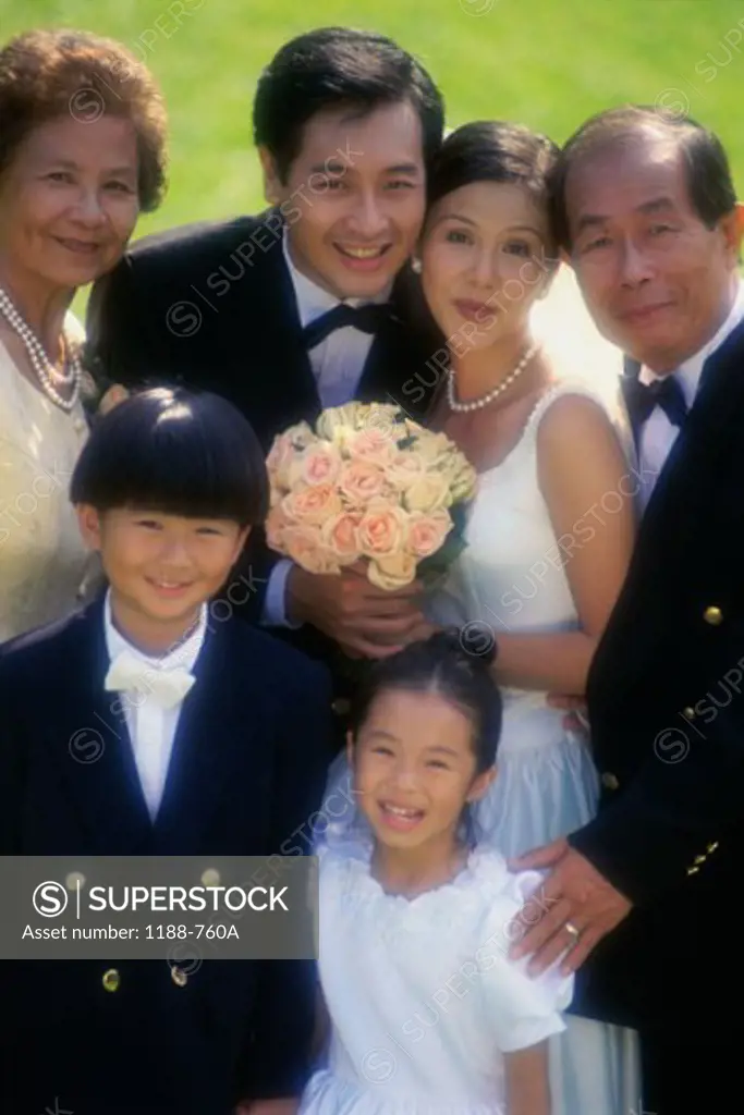 Portrait of a newlywed couple standing with their parents
