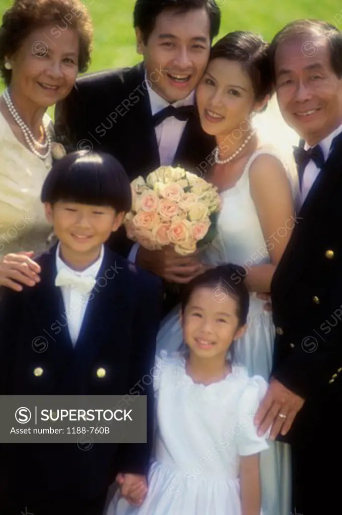 Newlywed couple standing with their family and smiling