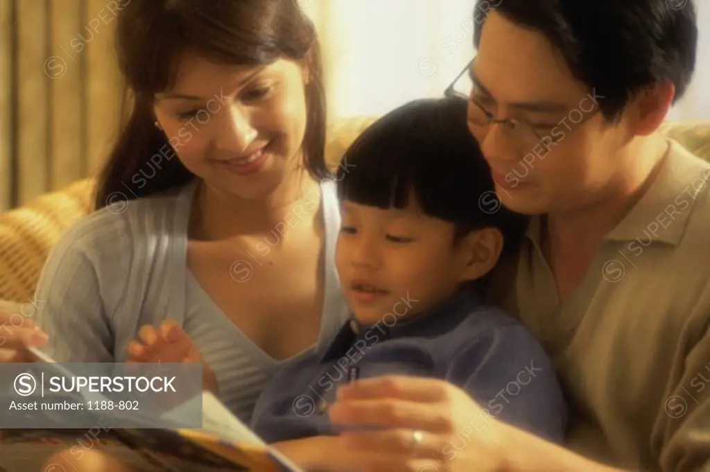 Parents with their son reading a book