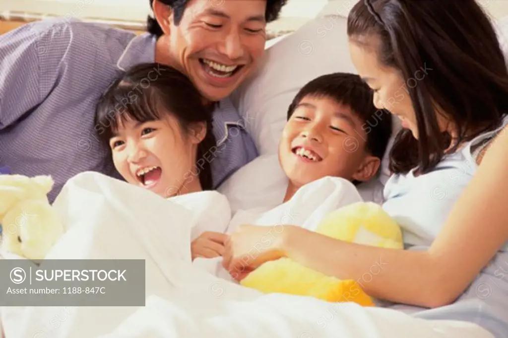 Mid adult couple with their son and daughter in the bed