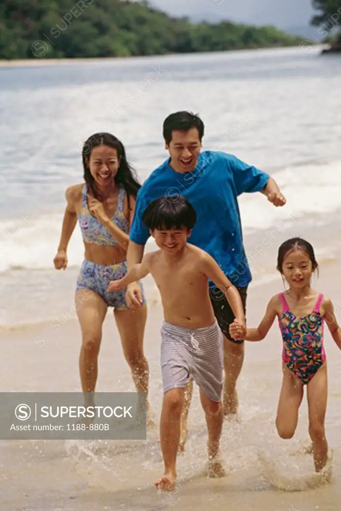 Family with two children running on beach