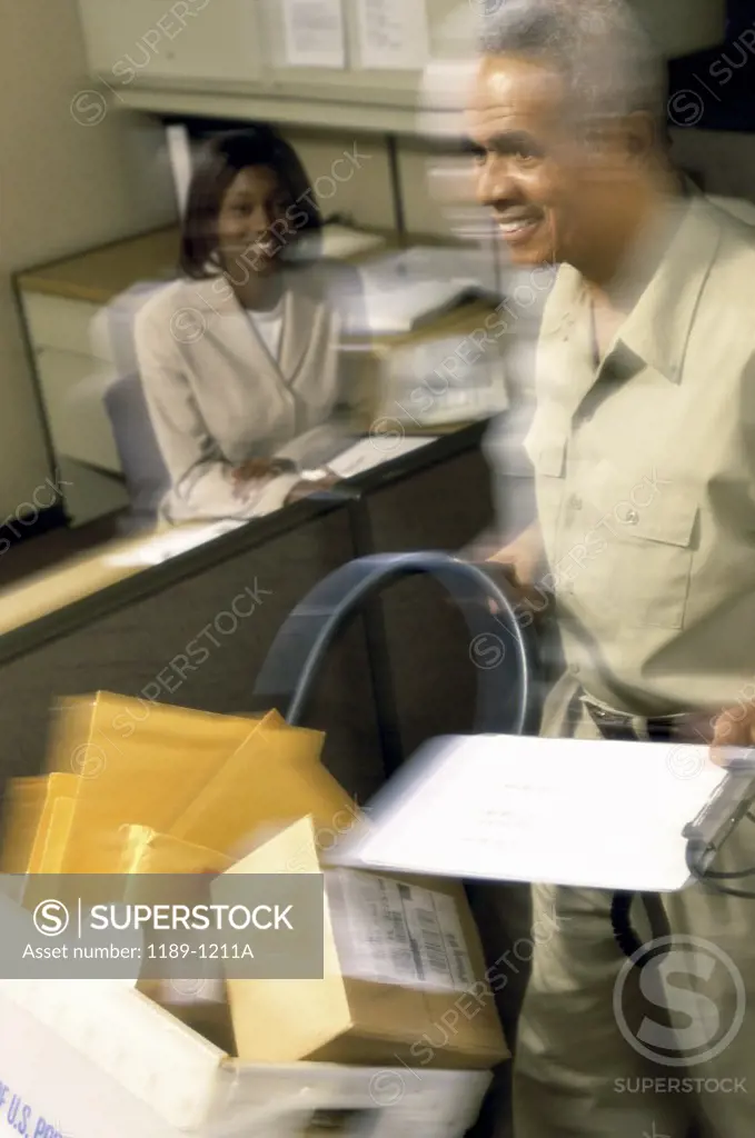 Mature man pushing a mail trolley in an office