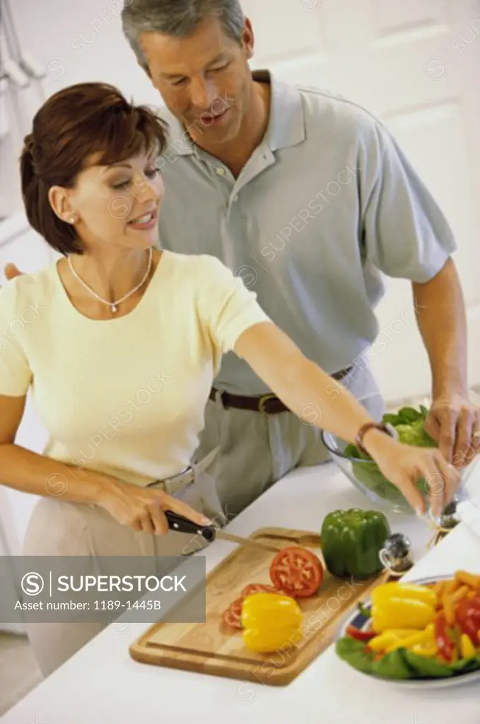 Mid adult couple talking to each other in a kitchen
