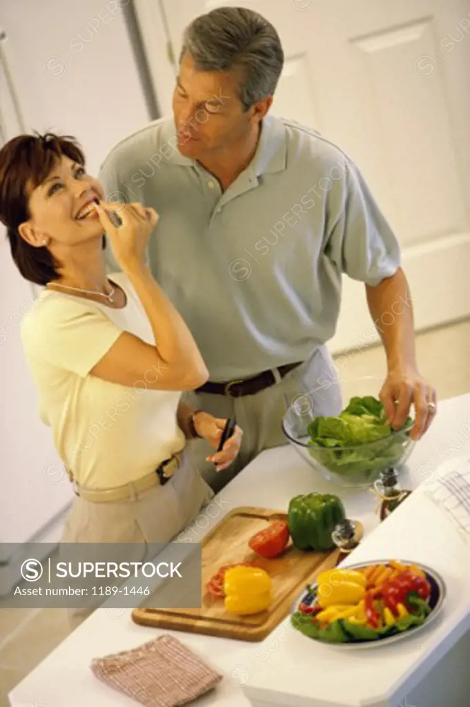 Mid adult couple talking to each other in a kitchen
