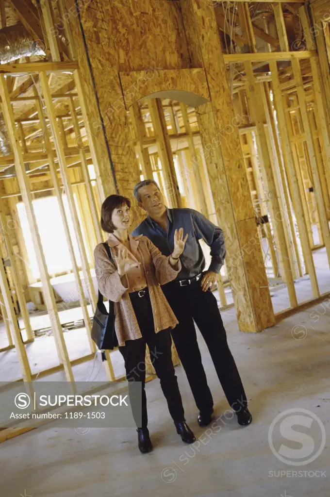 Mature couple standing in a house being built