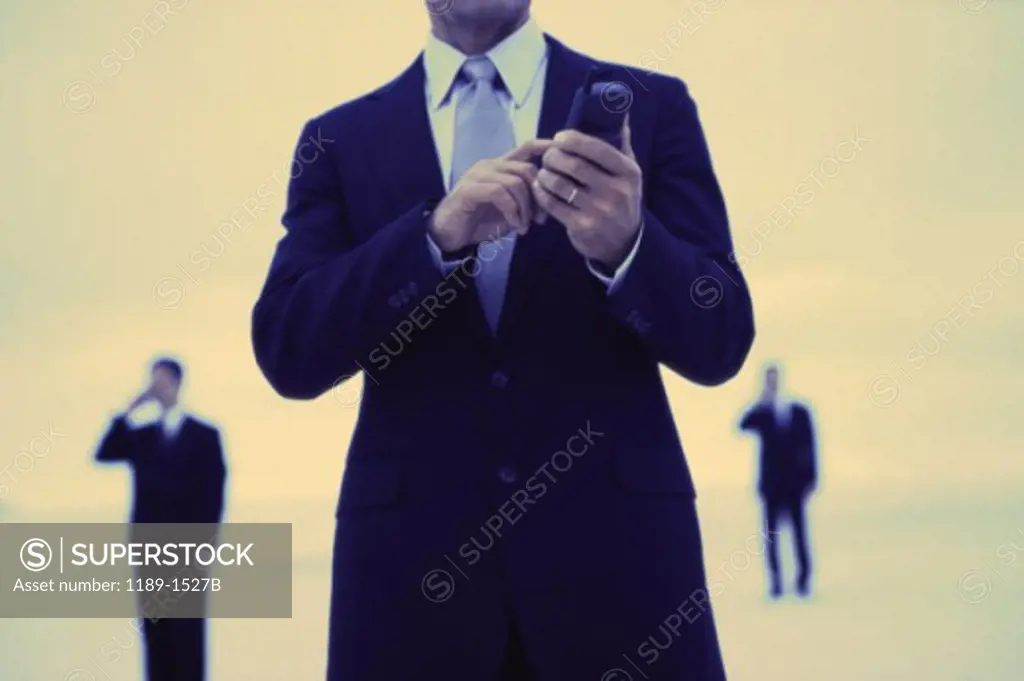 Mid section view of a businessman operating a mobile phone